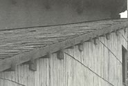 「鉄平石葺きの屋根と手割りのサワラ材の壁が美しい取り合いを見せる